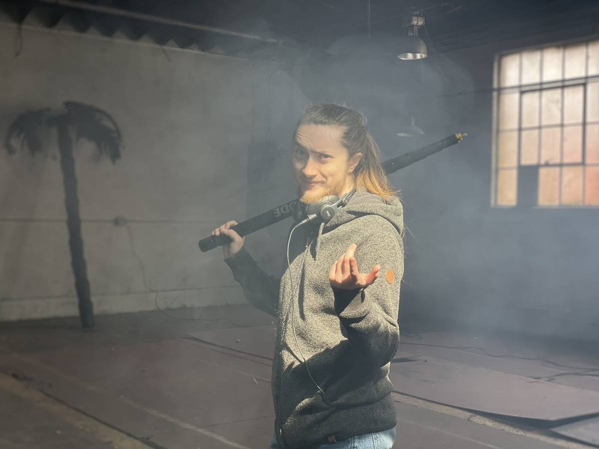 Boom operator in a smoky warehouse set