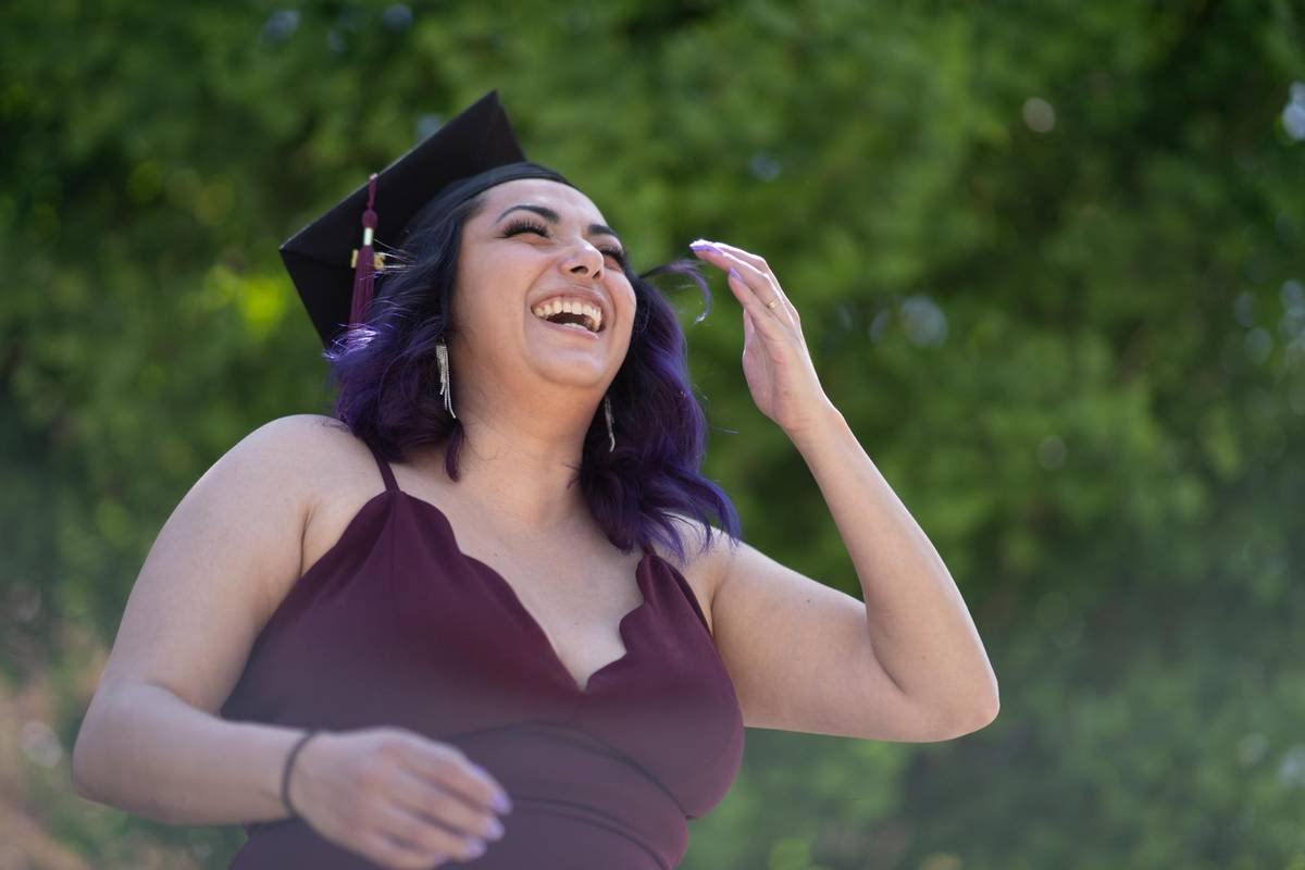 Graduate laughing in cap and gown