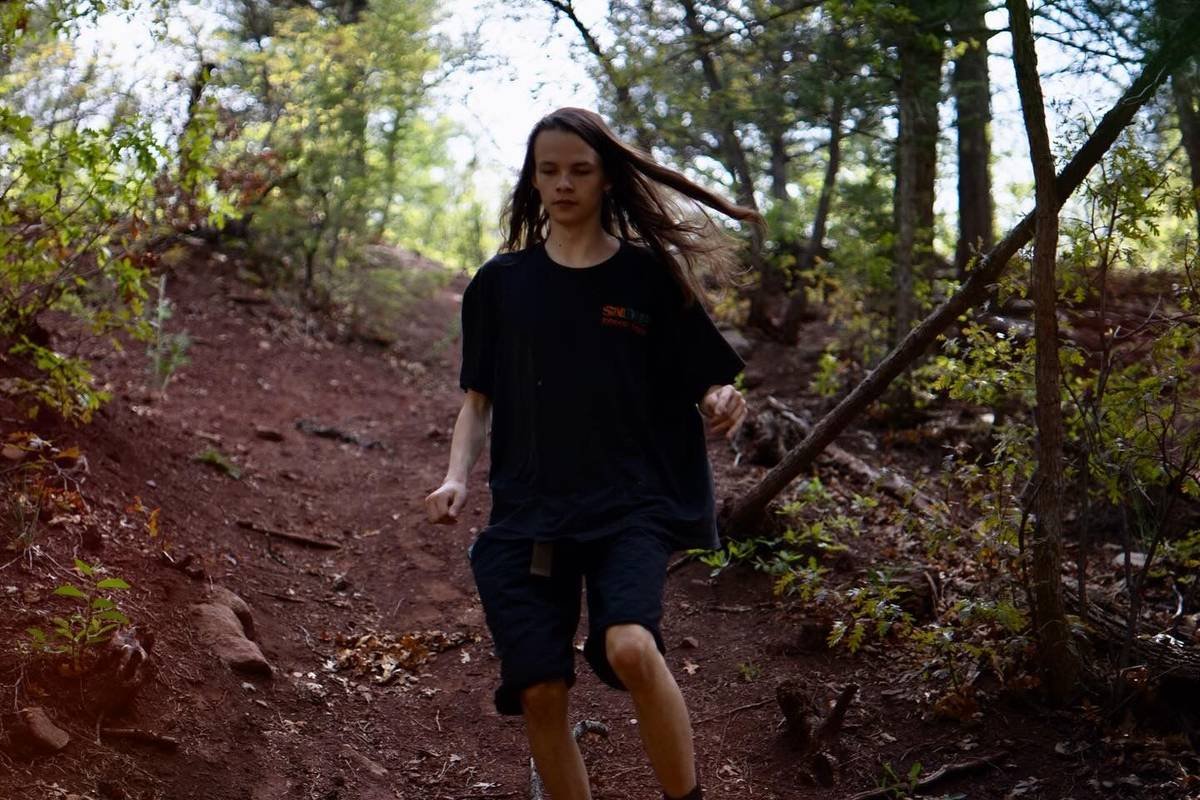 Portrait running down a red dirt trail