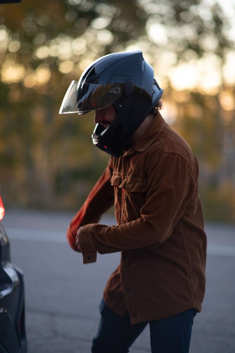 Rider pulling on a helmet at golden hour