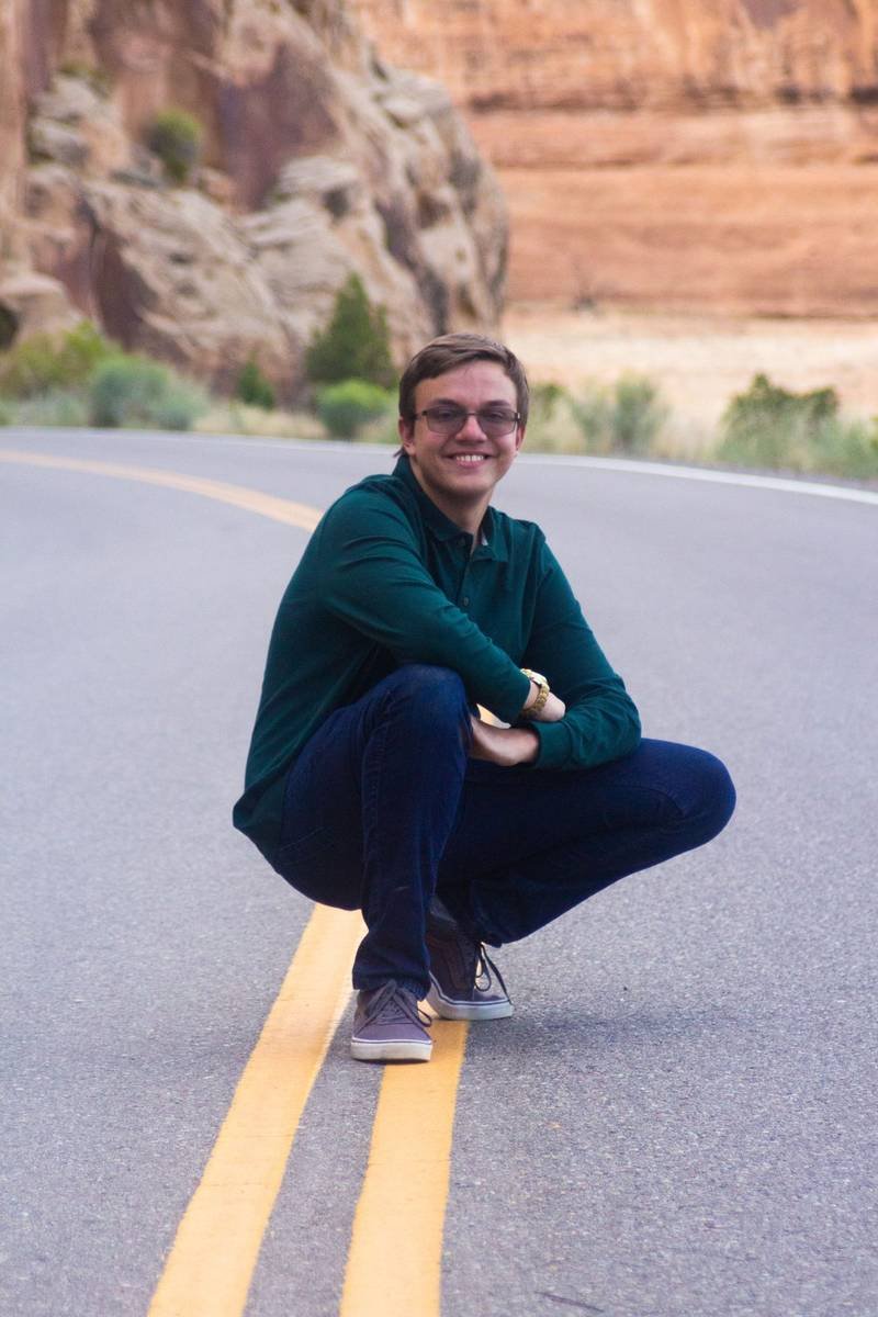 Senior crouched on the road at Colorado National Monument