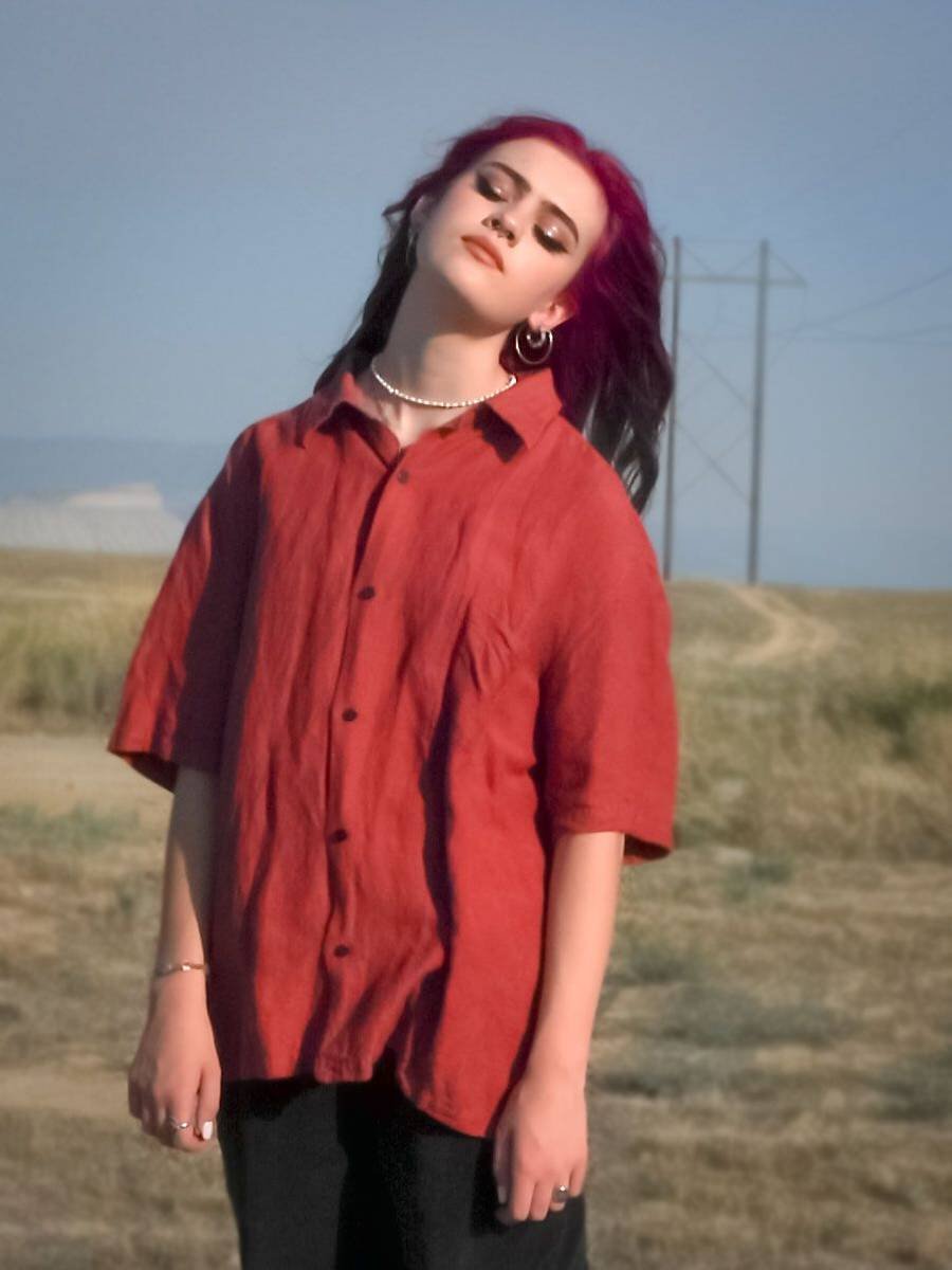 Senior in a red shirt in a field