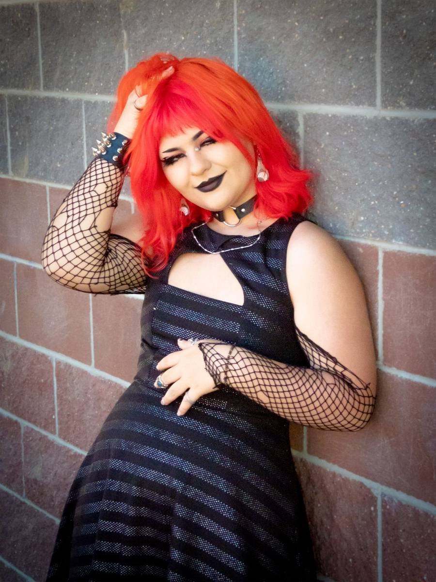 Senior portrait with red hair against a brick wall