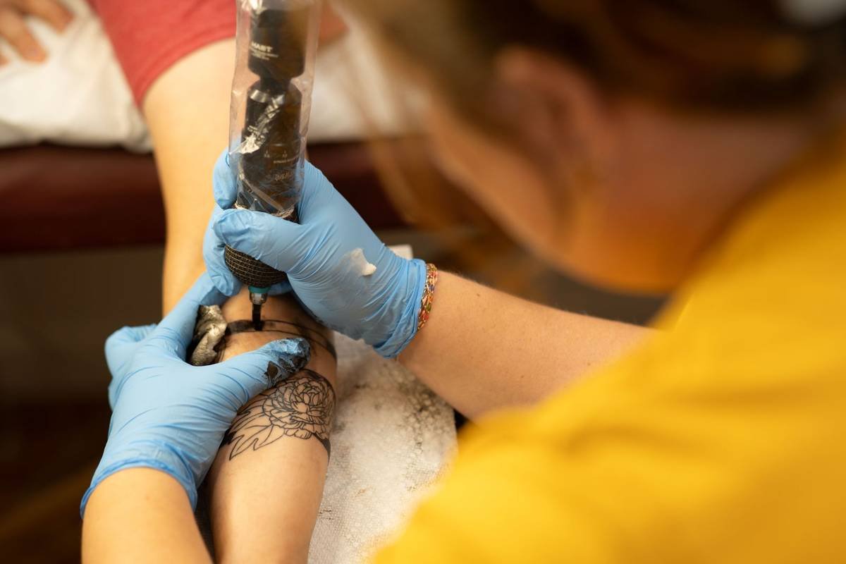 Tattoo artist at work in gloves