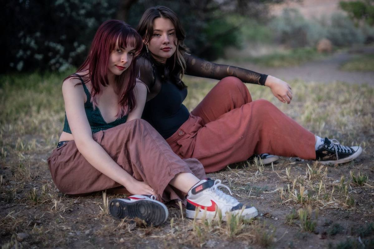 Two friends seated on a trail at dusk